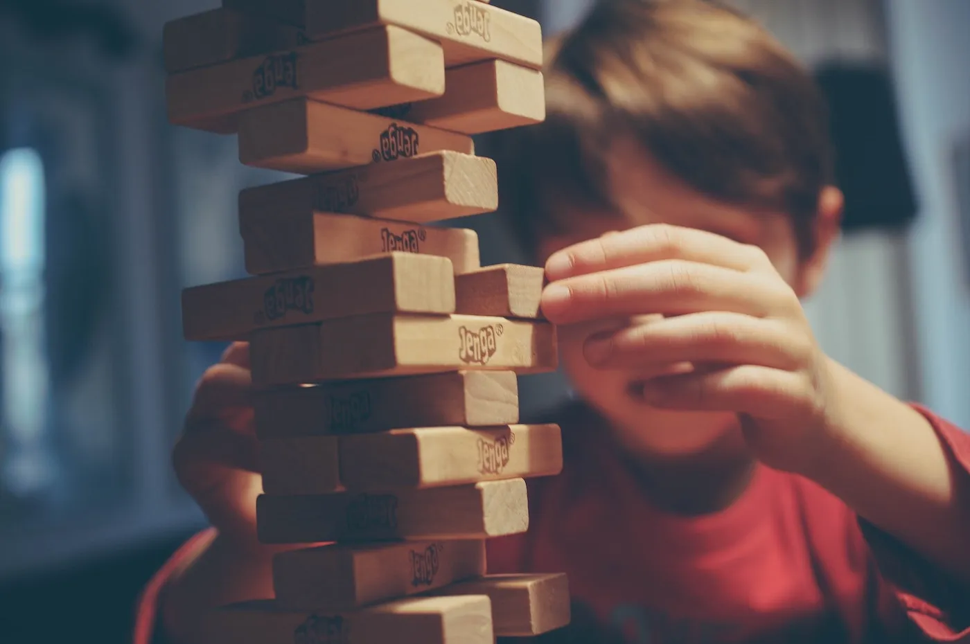 A kid playing Jenga as an analogy to the senior software engineer's soft skills and being able to take balanced decisions for the business